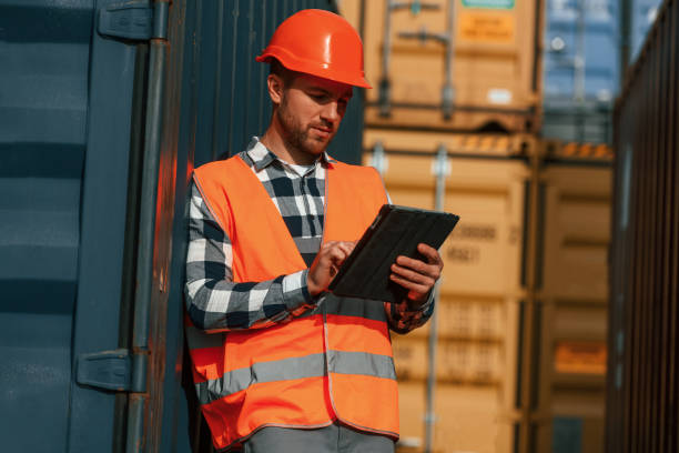 istock With digital tablet in hands. Male worker is on the location with containers 1457352860