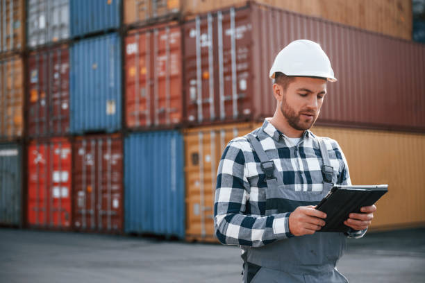 istock Digital tablet in hands. Male worker is on the location with containers 1457353090
