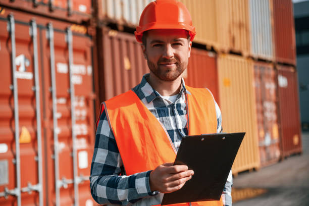 istock Standing with tablet in hands. Male worker is on the location with containers 1457353105