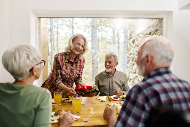 istock Happy senior couples talking during a meal in dining room. 1457353294