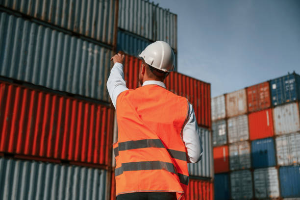 istock Rear view. Controlling the process. Male worker is on the location with containers 1457353517