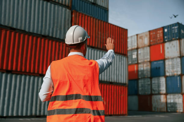 istock Rear view. Controlling the process. Male worker is on the location with containers 1457353529