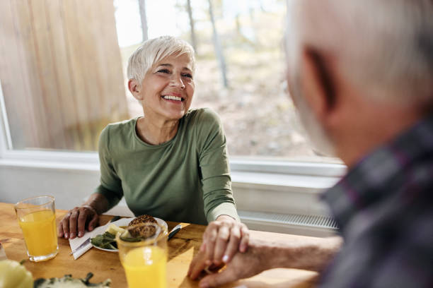 istock Happy mature woman talking to her husband during breakfast at dining table. 1457353909