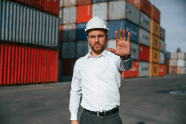 istock Stop, gesture. By the hand. Male worker is on the location with containers 1457354018