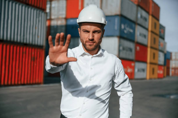 istock Stop, gesture. By the hand. Male worker is on the location with containers 1457354027