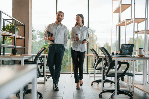 istock Front view. Man and woman are working in the modern office together 1457355336