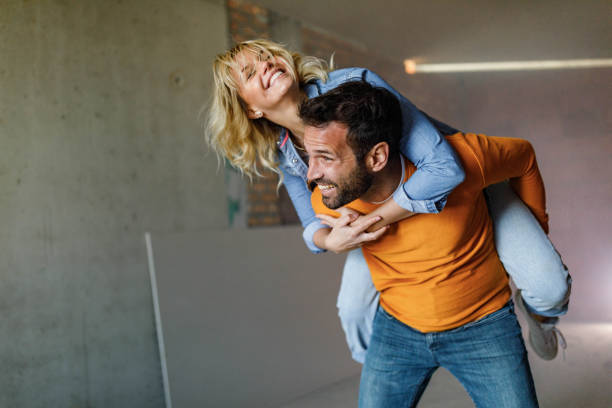 istock Happy couple having fun while piggybacking during home renovation process. 1457355706