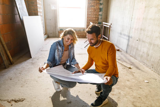 istock Happy couple analyzing plans at their renovating apartment. 1457355775