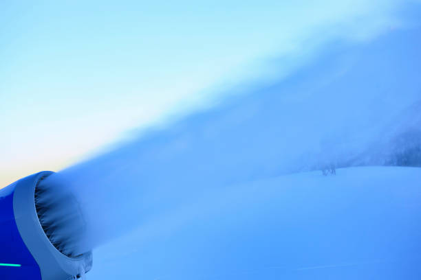 Snowmaking  with snow gun.  Ski slope artificial snowing. Ski resort  with snow cannon - snow making machine. Beautiful winter nature. Fresh snow on the top of  mountains.  High mountain landscape  Ski area.