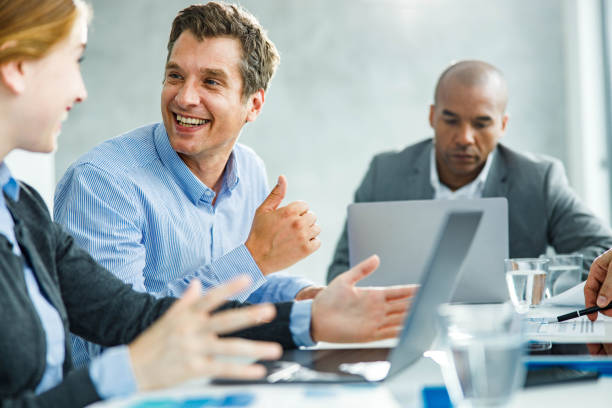 istock Happy business colleagues talking while working on computer in the office. 1457357273