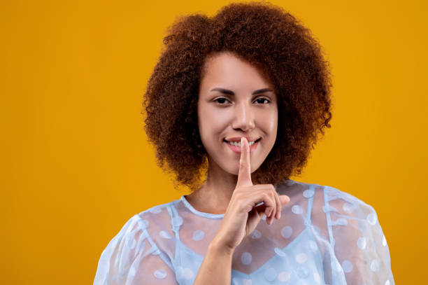 istock Pretty young woman showing a hush sign 1457357352