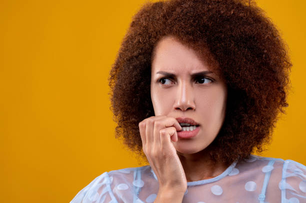 istock Curly-haired young woman looking uncretained and infance 1457357408