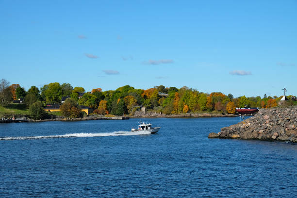 istock View over the strait between two islands with autumn colored trees behind and moving police boat, Vallisaari, Helsinki Biennial 2021 1457361136