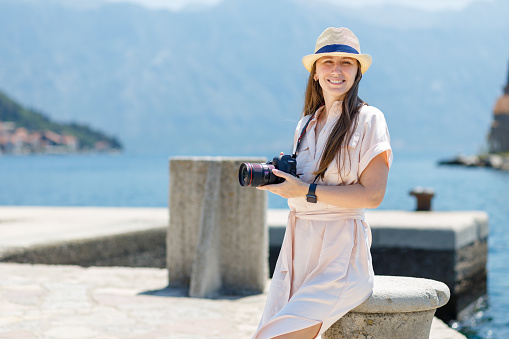 Young woman taking photo on camera on her vacation trip in Europe.