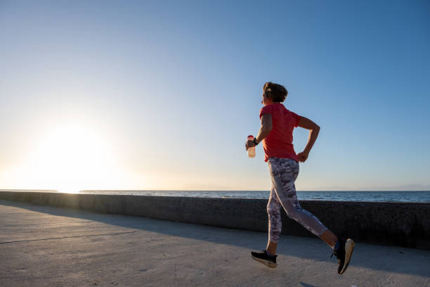 istock Female running with a water bottle at sunset 1457373176