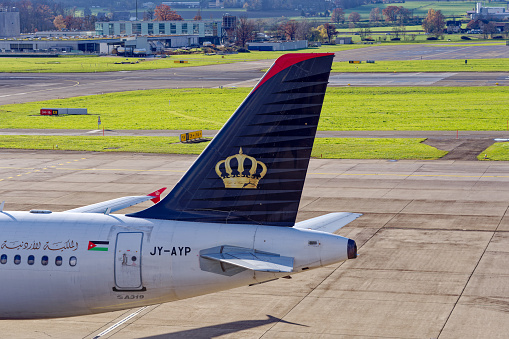 Close-up of tail of taxiing airplane of Royal Jordanian Airbus A319-132 register JY-AYP at Zürich Airport on a blue cloudy autumn day. Photo taken November 26th, 2022, Zurich, Switzerland.
