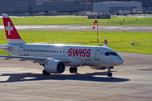Swiss airplane Airbus A220-100 register HB-JBA taxiing on a blue cloudy autumn day. Photo taken November 26th, 2022, Zurich, Switzerland.