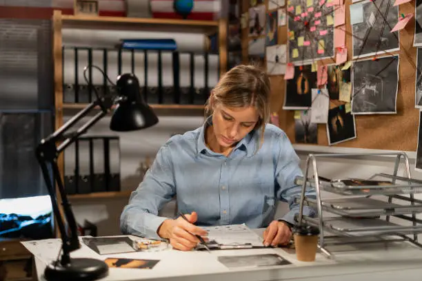 Photo of Detective working with documents at desk in her office