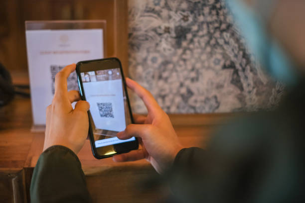 istock Young Asian Traveller Scanning QR Code To Fill in Registration Guest Form at Hotel 1457376158