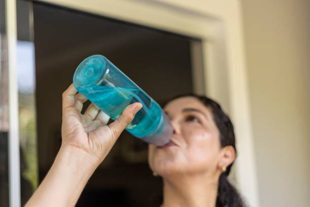 istock Latin woman drinking water from a green bottle 1457377328