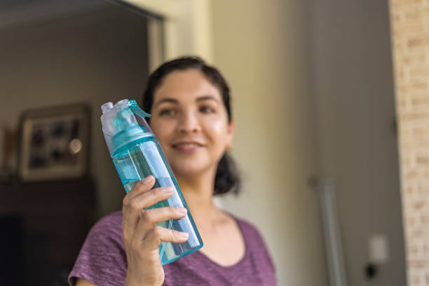 istock Latin woman drinking water from a green bottle 1457377348