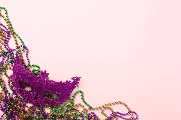perles de mardi gras et masque de carnaval sur fond violet. conception de la bannière de vacances mardi gras. pose plate, vue de dessus, au-dessus. - mardi gras parade new orleans grass photos et images de collection
