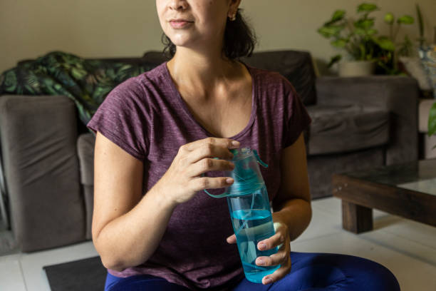 istock Latin woman on the floor doing physical exercises with water bottle 1457377663