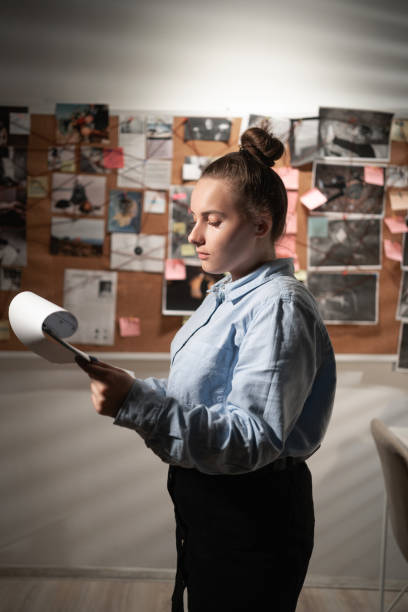 istock Dective working with documents near investigation board in her office. 1457378573