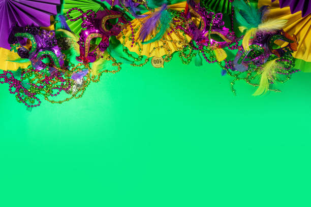 Mardi Gras carnival background Mardi Gras colourful holiday greeting card background with festival masquerade accessories, decor, carnival mask, beads, feathers, fan on bright background traditional yellow purple green colors purple and gold masquerade masks stock pictures, royalty-free photos & images