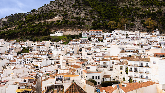 Aerial view of white houses, stretches across the slope of the mountains. Mijas Pueblo, typical white-washed hillside village (Pueblo Blanco). Costa del Sol, Andalusia, Spain.
