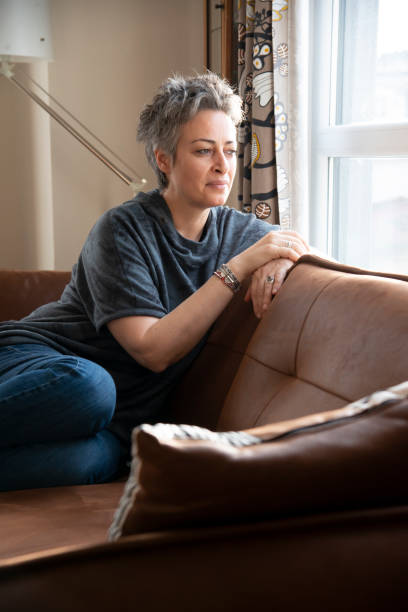 istock Woman looking out the window at home 1457385090