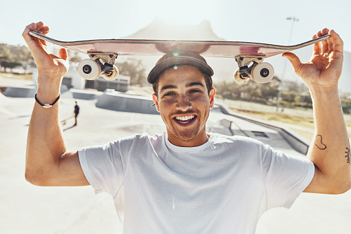 Portrait, skateboard and skater man in city, street or skate park ready for skating practice. Exercise, skateboarding sports and happy male preparing for fitness workout or training in town outdoors.