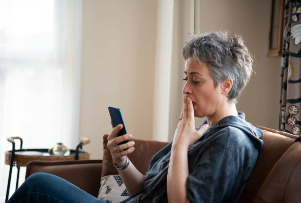 istock Woman using mobile phone at home 1457387218