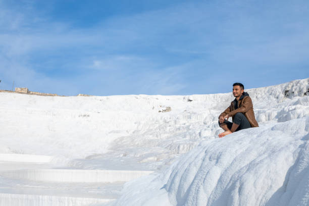 istock Man sitting on the travertines in Pamukkale, Turkey 1457387265