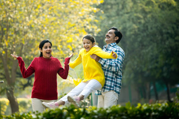 istock Cheerful parents playing with daughter at park 1457390103