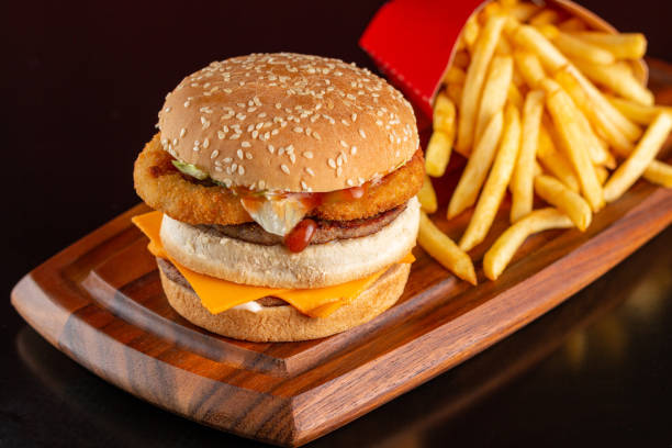 istock Delicious hamburger onion rings, cheddar cheese, accompanied by fries. 1457391028
