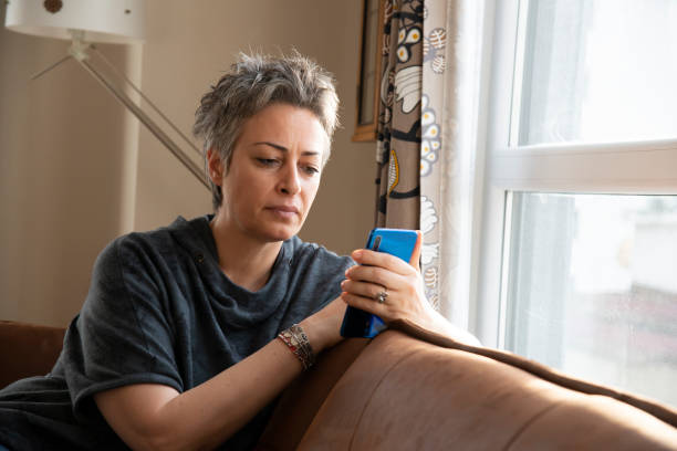 istock Woman using mobile phone at home 1457391081
