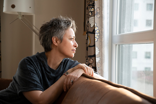 Woman looking out the window at home