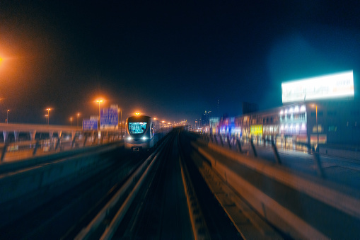 Dubai metro on the background of cityscape at night