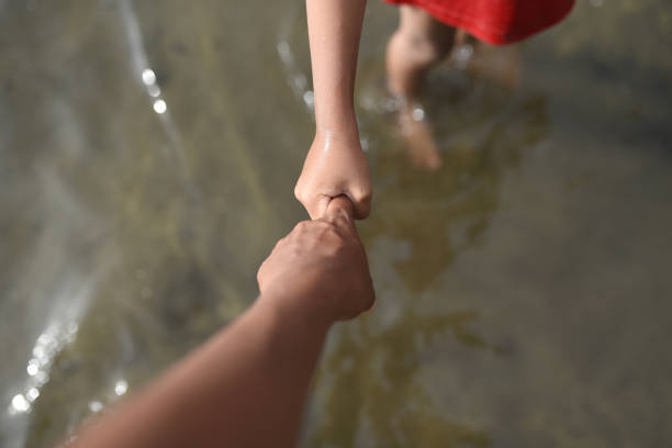 istock Child's Hand Holding Mother's Hand 1457392039
