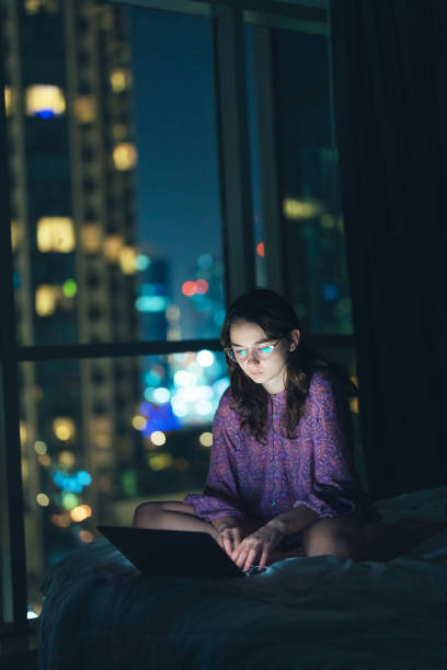 istock Woman in eyeglasses working at night in megapolis 1457392061