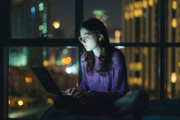 istock Woman in eyeglasses working at night in megapolis 1457392093