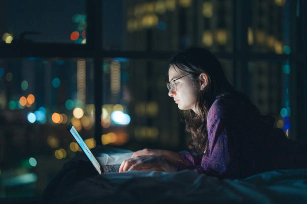 istock Woman in eyeglasses working at night in megapolis 1457392112