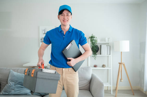 An Asian young Technician service man wearing blue uniform checking electrical appliances in home stock photo
