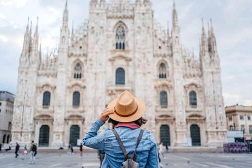 Beautiful young female tourist enjoying the view of the cathedral in Milan, Italy.