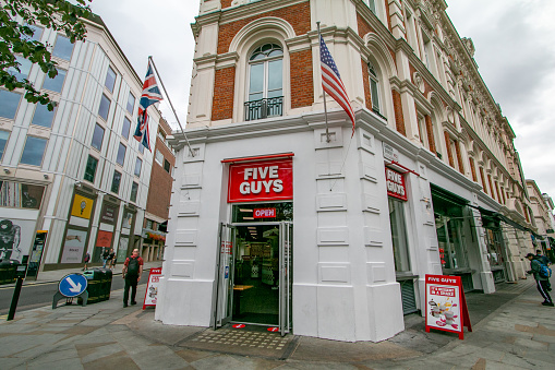 People walking past Five Guys Fast Food Restaurant on Garrick Street at Covent Garden in City of Westminster, London