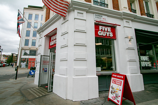 Commercial signs visible near Five Guys Fast Food Restaurant on Long Acre at Covent Garden in City of Westminster, London