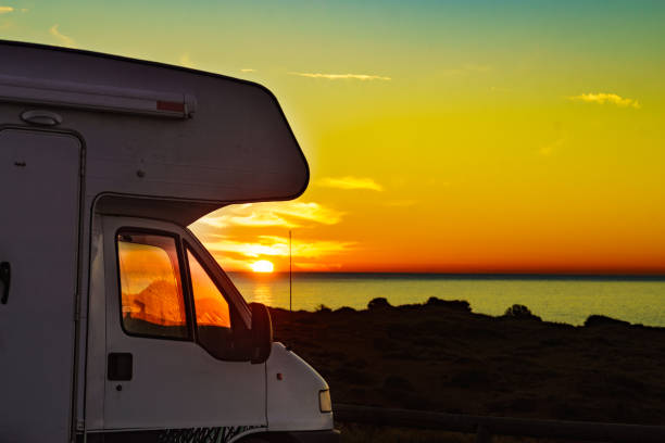 istock Camper vehicle on beach at sunrise 1457398144