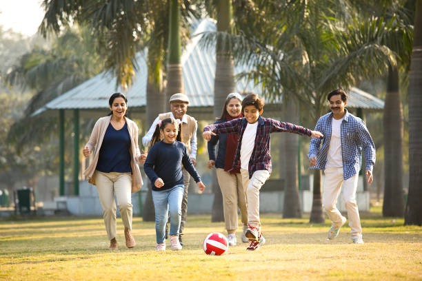 Multi generation family playing soccer at park