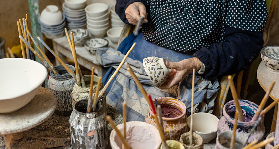 Hands of a potter, creating an earthen jar.